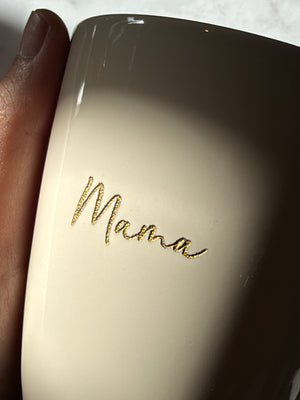 Close-up van de naam Mama, gegraveerd en gevuld met gouden wax op een glanzende beige tas