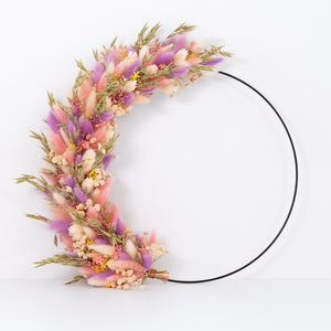Flowerhoop met een combinatie van paarse, groene en roze droogbloemen op een zwarte metalen ring