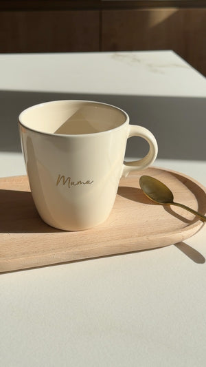 Gegraveerde mok met naam Mama in goud op tafel in het ochtendlicht