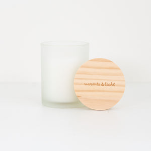 Geurkaars in een frosted glas met de tekst 'warmte en licht' gegraveerd op het houten deksel 