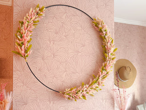 Grote flowerhoop op maat met een diameter van 80 centimeter en roze, groene en natuurlijke droogbloemen