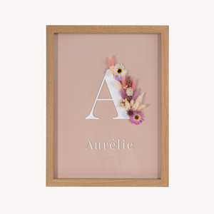 Letterkader met zachte rozige en crème kleurige droogbloemen met initiaal en naam in acryl