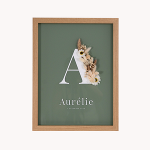 Letterkader met droogbloemen in crème en natuurlijke kleuren op een olijfkleurige acryl achtergrond