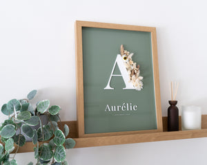 Letterkader met droogbloemen op een olijfkleurige achtergrond op een houten schilderplank omringd met zachte decoratie