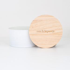 Witte luxe geurkaars met 3 houten lonten en een houten deksel met de tekst 'een lichtpuntje' op gegraveerd voor een modern interieur