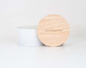 Witte luxe geurkaars met 3 houten lonten en een houten deksel met de tekst 'een lichtpuntje' op gegraveerd voor een modern interieur